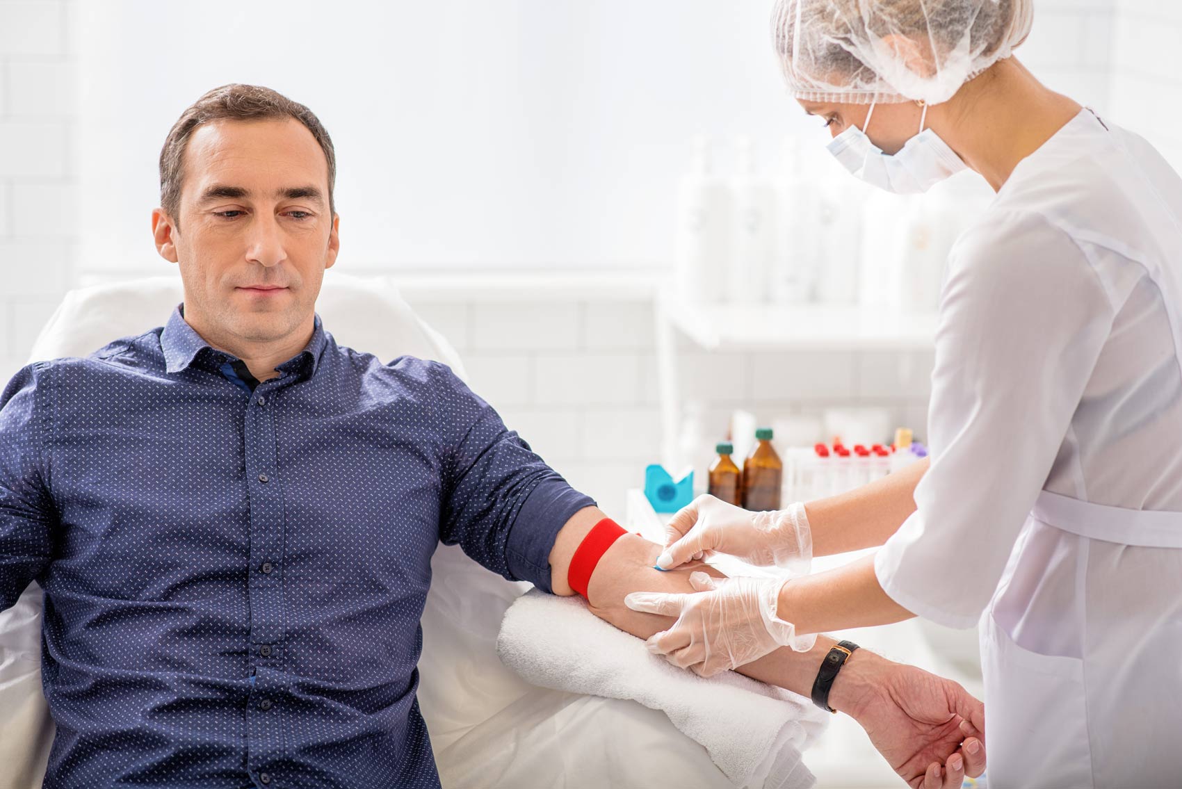 Man on bed having a blood test